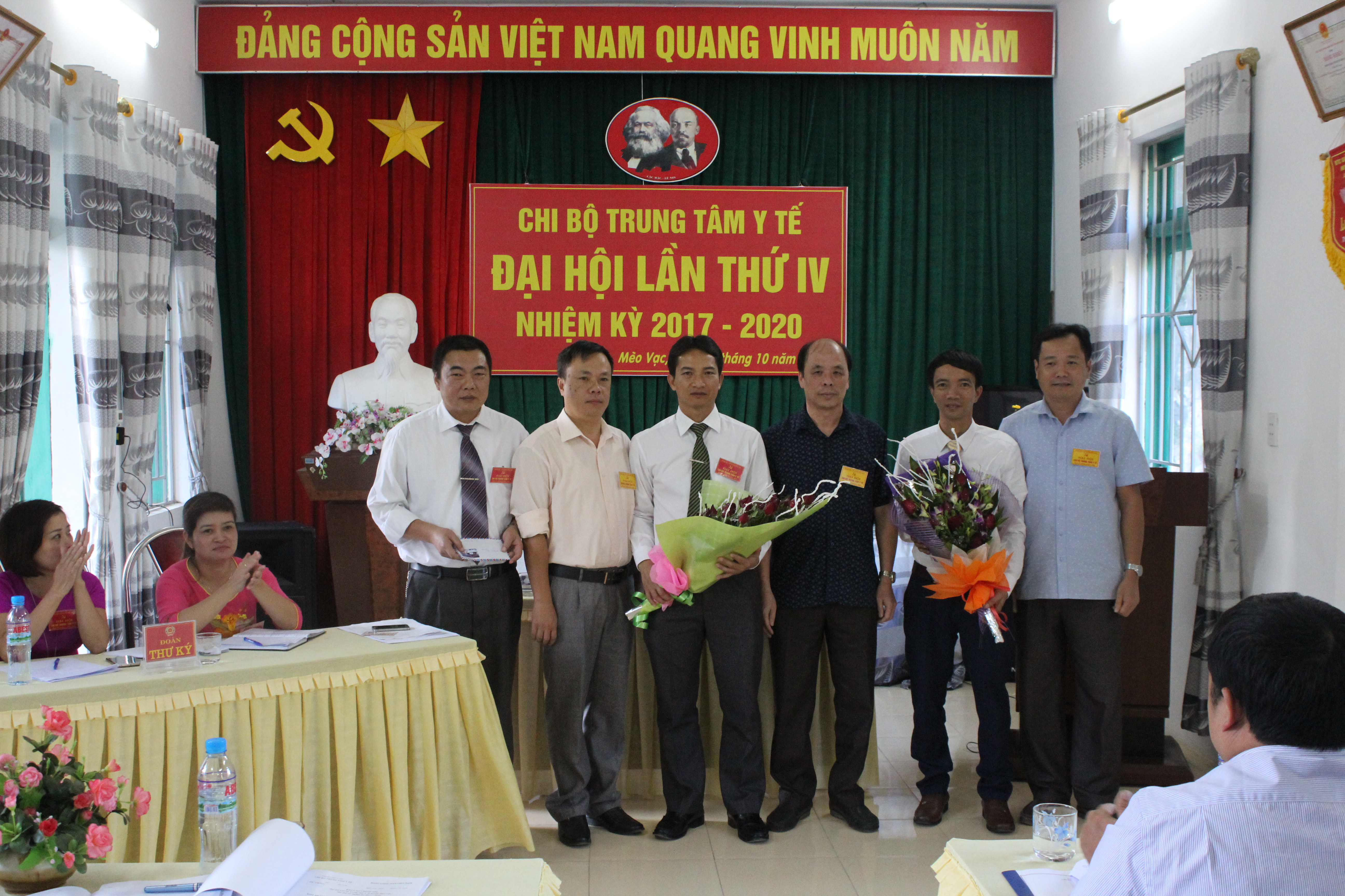 Đ/c Ngô Chí Cường và đại diện Chi bộ BVĐK huyện, Chi bộ phòng Y tế - Dân số tặng hoa chúc mừng Ban Chi ủy TTYT huyện Mèo Vạc nhiệm kỳ 2017 - 2020.